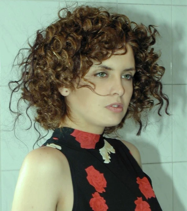 a woman with curly hair is wearing black and red