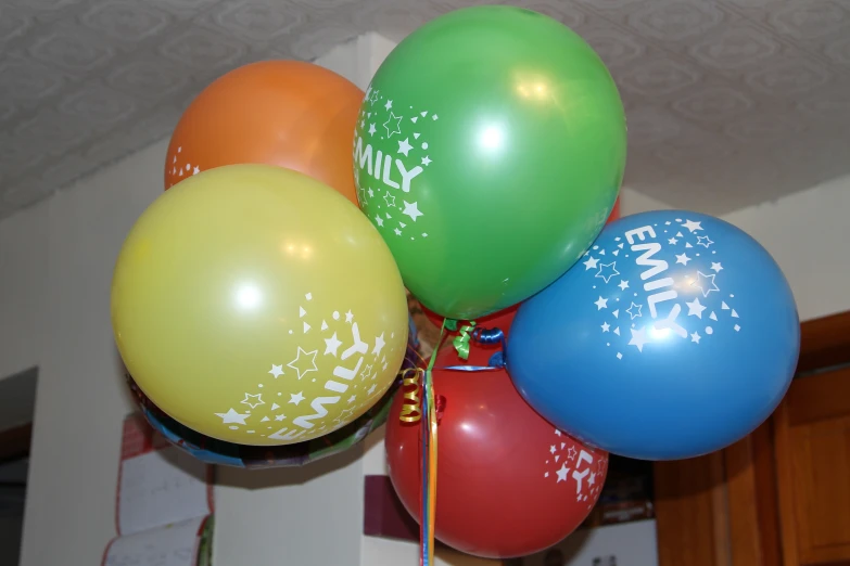 five balloons tied to a ceiling in a house