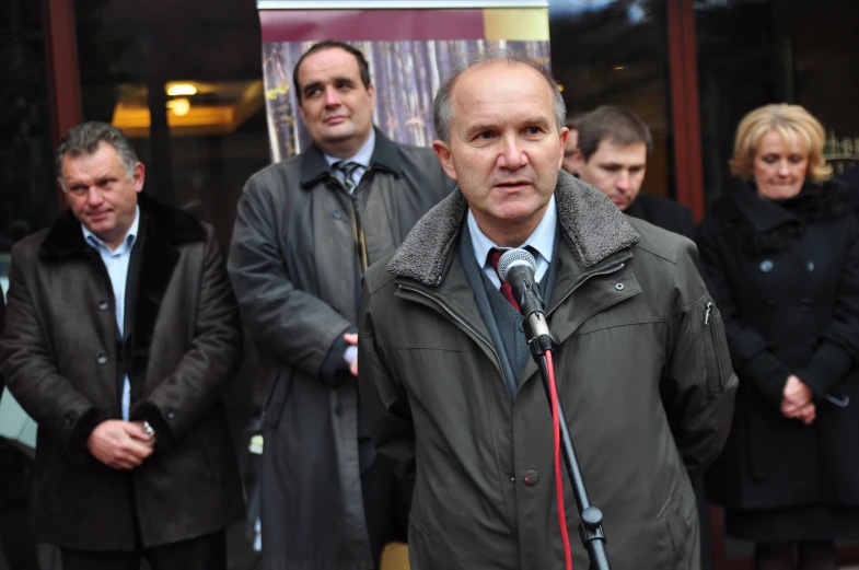 a man standing in front of people holding a microphone