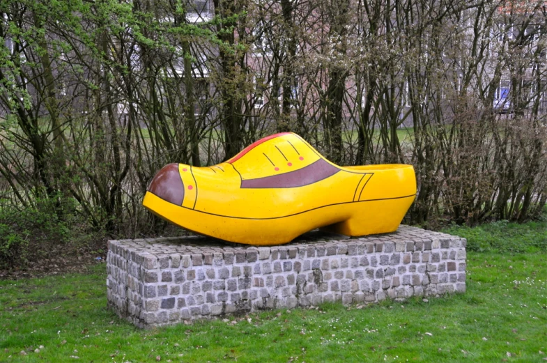 a statue of a shoe on a brick wall