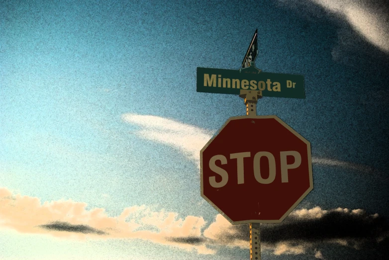 a stop sign and street signs are posted at minneapolis avenue