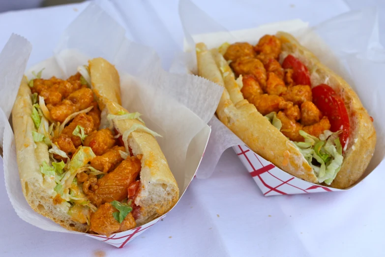 chicken sandwiches are displayed in paper bowls on a table