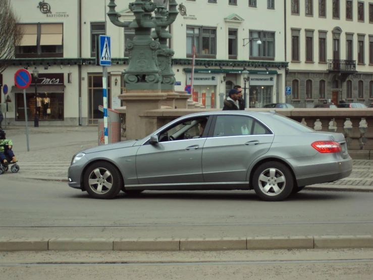 a grey car that is stopped at the intersection