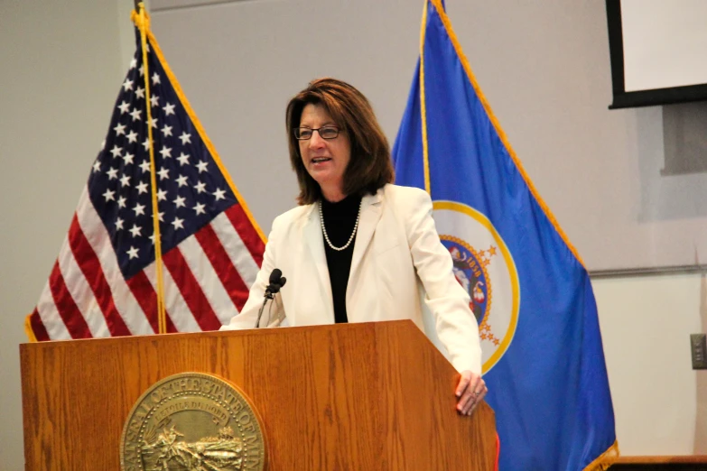 a woman is standing behind a podium talking