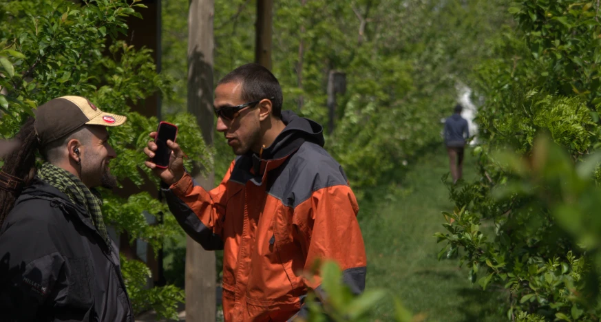 two men in the woods using their cell phones