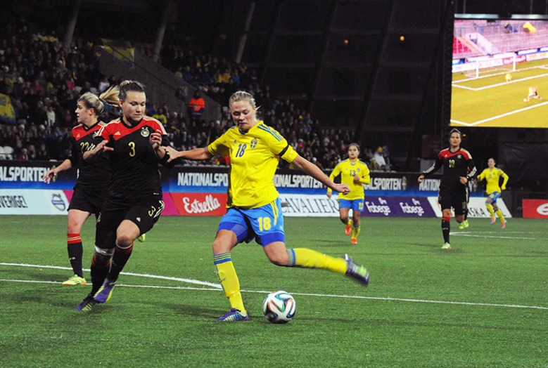 a group of women play soccer in front of an audience