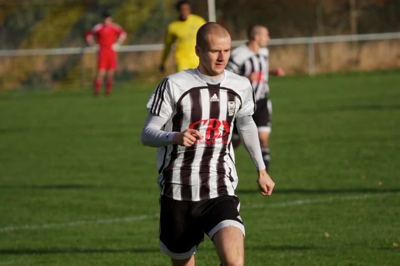 a man in a striped shirt playing soccer