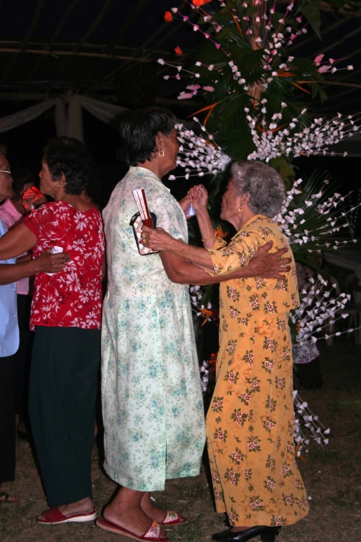 two women are touching each other as people stand in the background