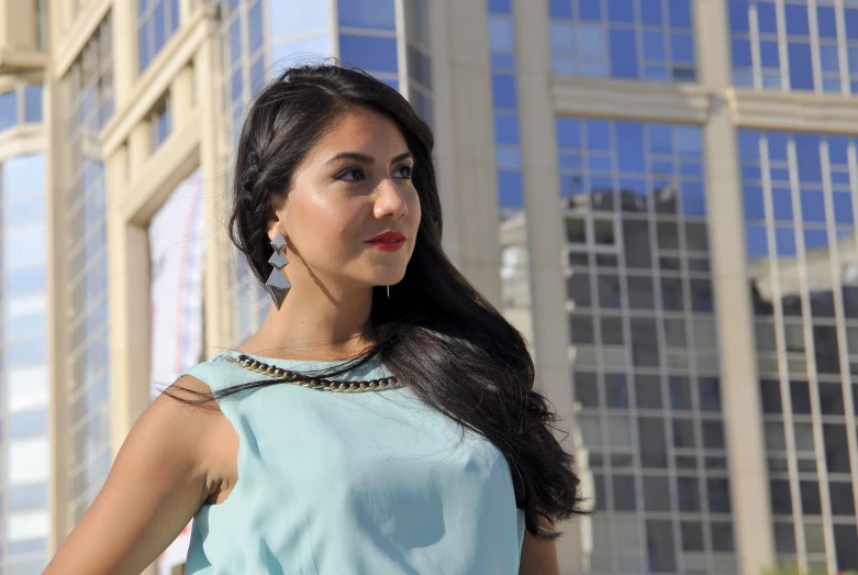 an asian woman stands outside in front of some buildings