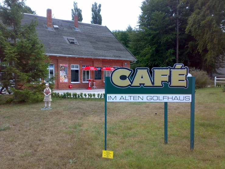there is a cafe sign on display in front of the lawn