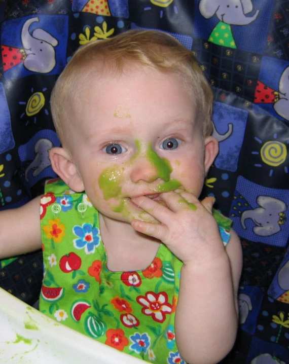 a small child is covered in paint and eating