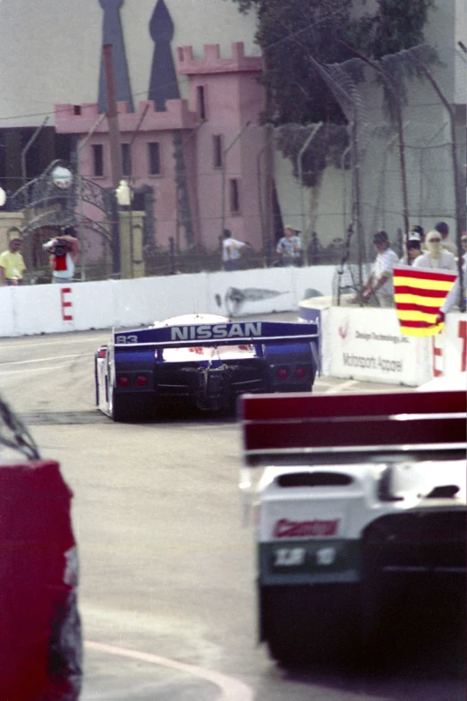 two cars racing in front of each other at an outside event