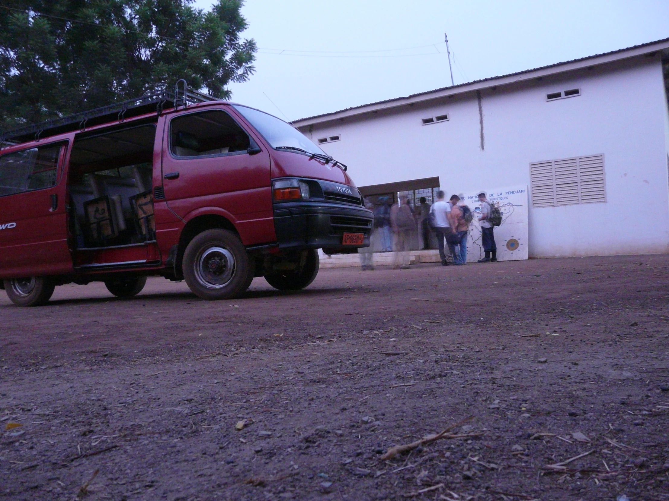 the red van is parked beside the building