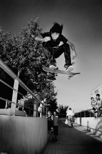 black and white image of a boy doing a skateboard trick