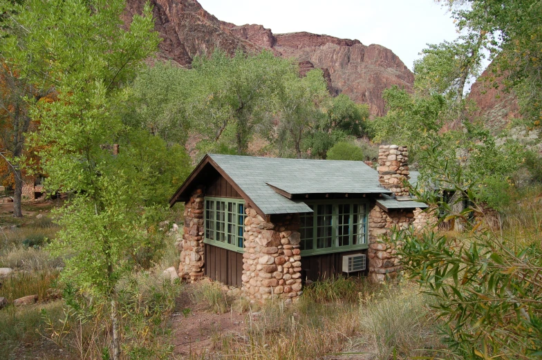 a small log cabin nestled in the middle of a mountain