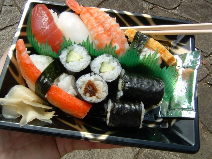 the sushi tray has several different types of foods in it