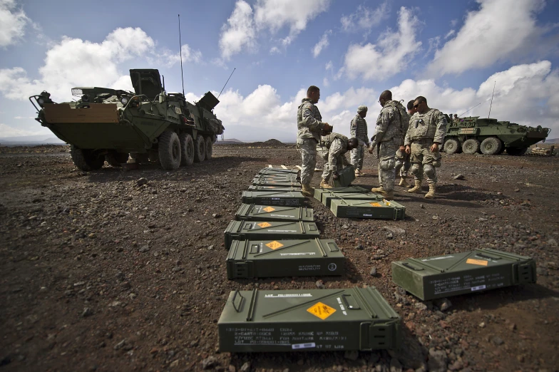 there are many military men standing near some tanks