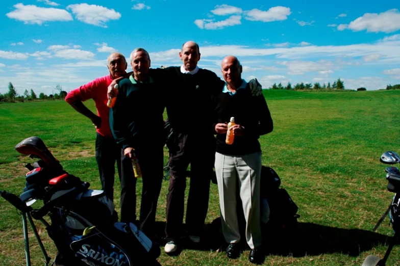 three men standing next to each other, one is holding up a golf ball