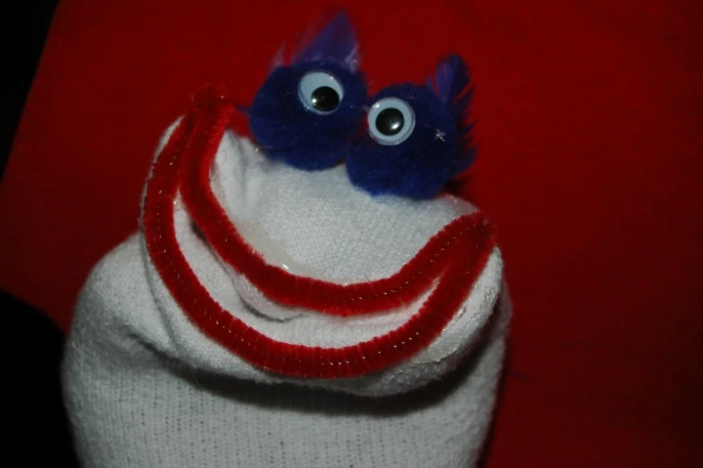 this is a red and white hat with an ugly blue face