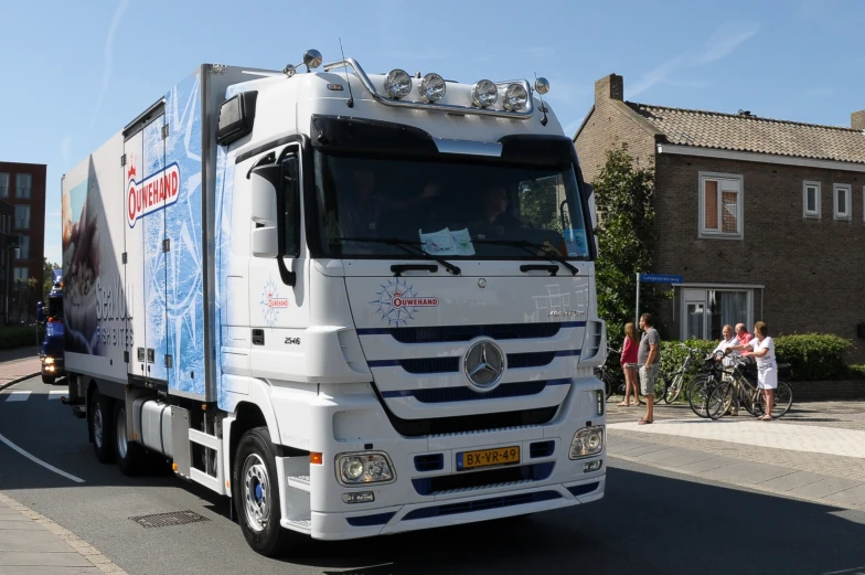 a large white truck driving down a street