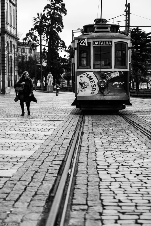 a trolley car going down a street with graffiti on it