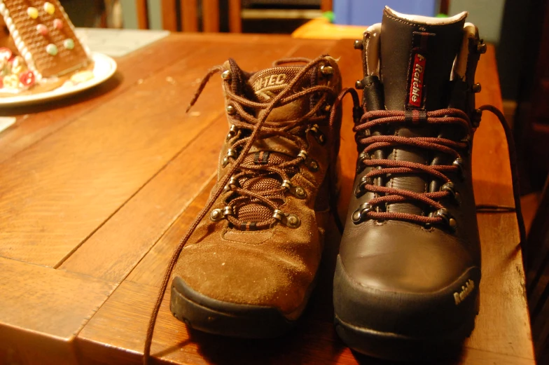 a couple of brown boots sitting on top of a wooden table
