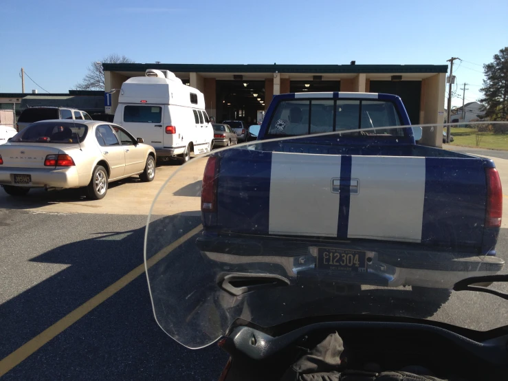 the back of a police motorcycle in front of a couple parked on the side of the road