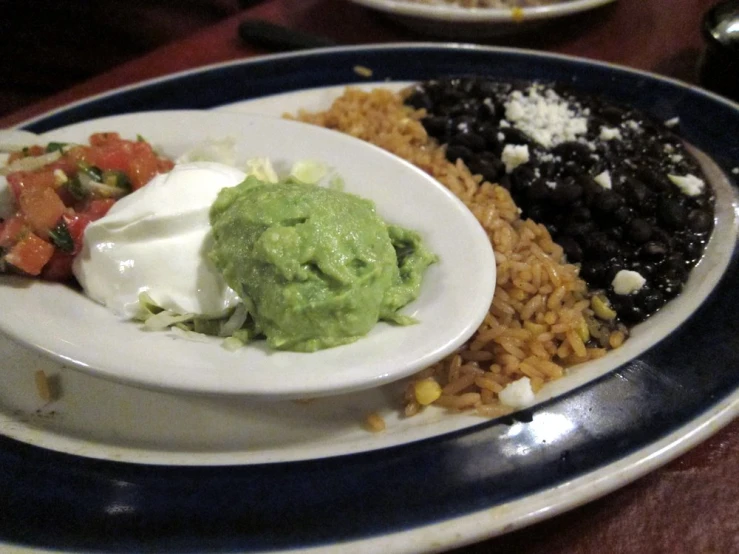 a plate topped with rice, beans, and guacamole