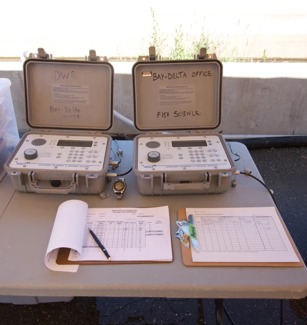 a table with two briefcases containing papers, a pen and scissors