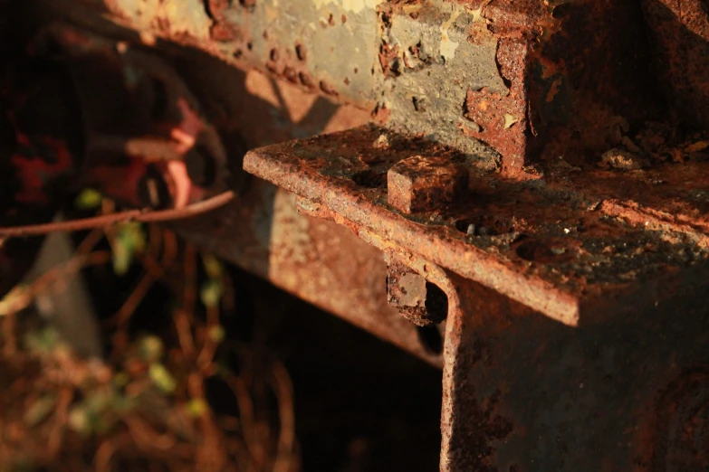 there is a rusted bench next to a wall