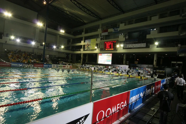 swimming in an arena has been heated up and people watch from the stands