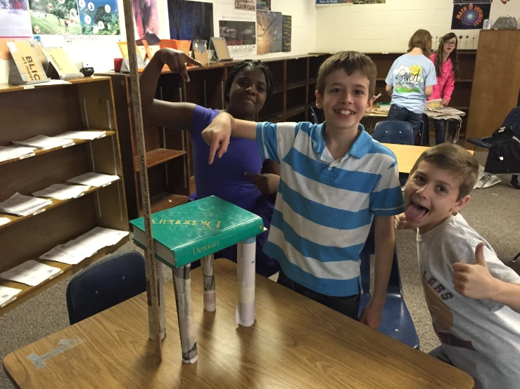 two boys showing off one of the toys he made