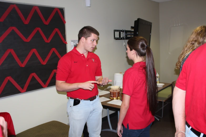 two people stand facing each other in a room