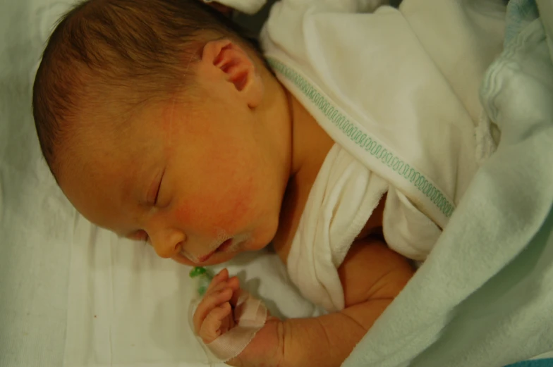 a baby is laying on top of a white sheet