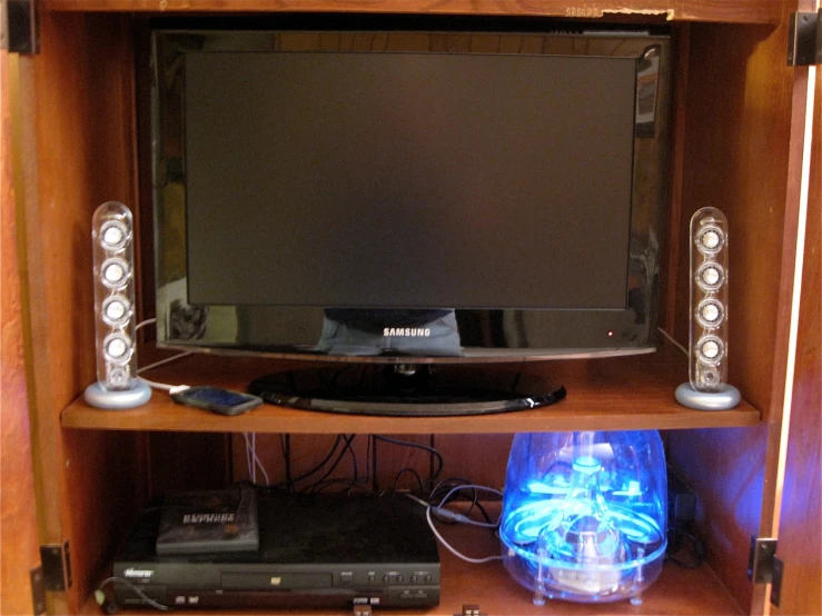 a wooden shelf with some electronic equipment and speakers