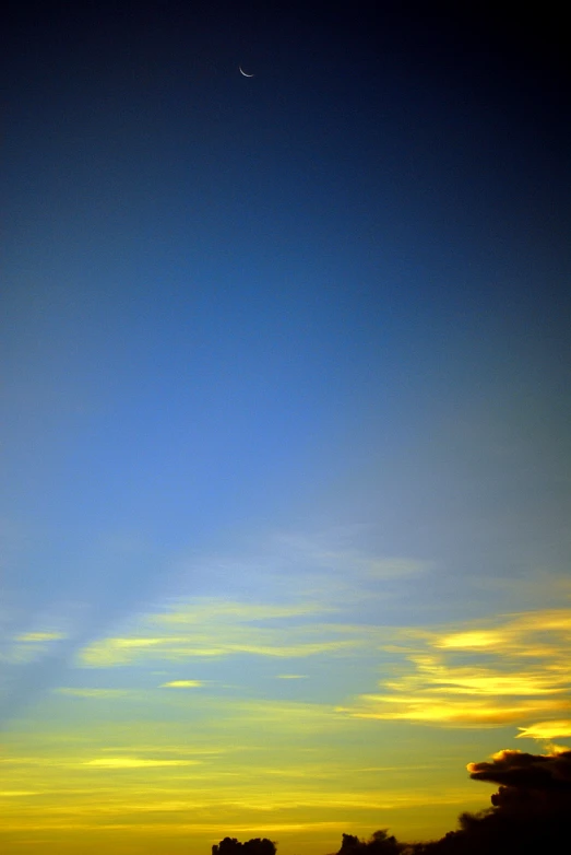 the night sky, with some clouds and a plane in the distance