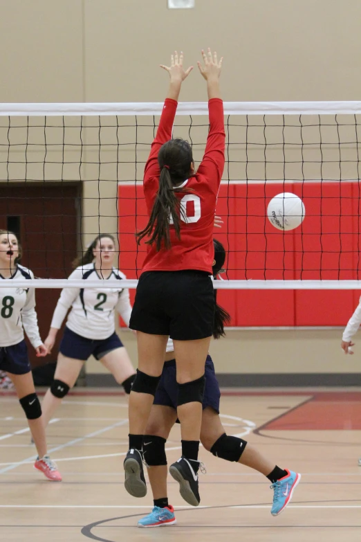 there is a girl playing volleyball that is on the court