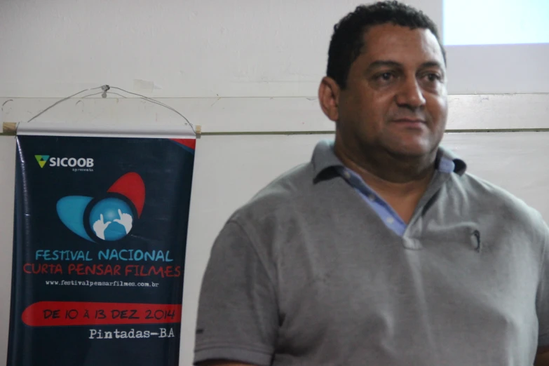 a man is posing for a picture in front of a banner