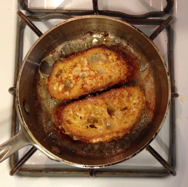 two pieces of food fry in a frying pan