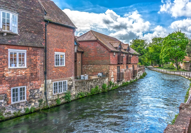 a narrow, cobblestone street runs alongside an old brick building