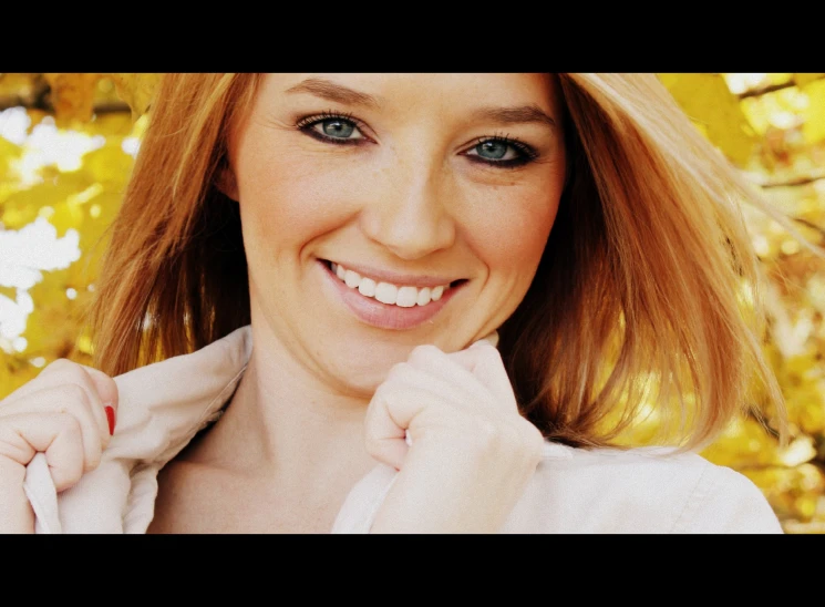 a close up of a person smiling with red hair