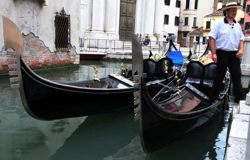 two gondola's sitting beside a man on a sidewalk