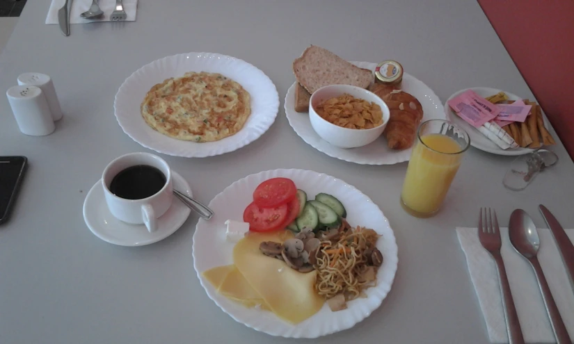 three plates full of breakfast food and one bowl of food with drink