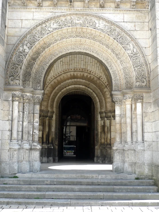 the entrance to the large, stone building with a clock on it's face