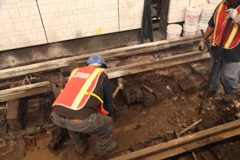 a person in orange vest working on tracks