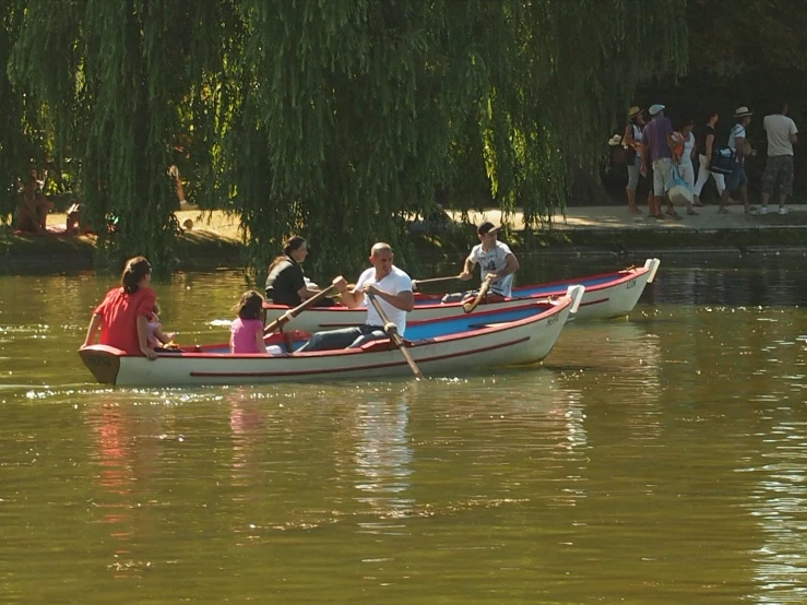 people are in a small boat on the lake