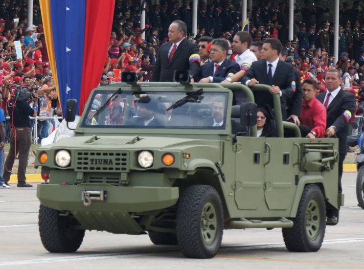 a military vehicle in a parade filled with people