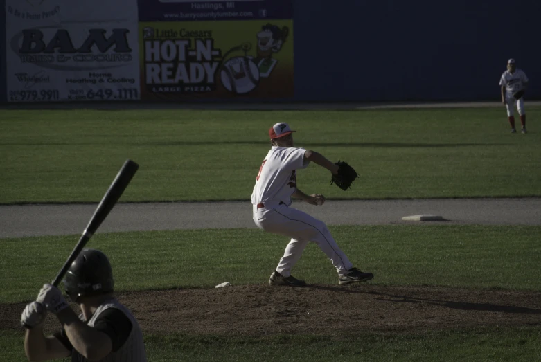 a pitcher pitching at a baseball game in the middle of a pitch