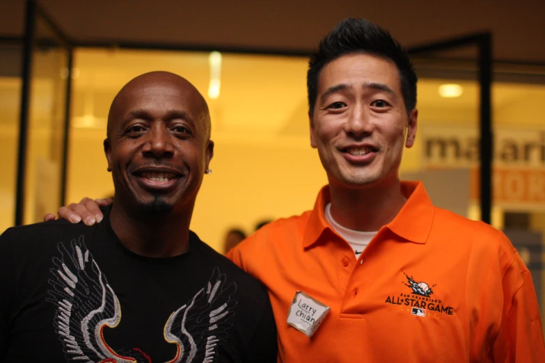 two men smiling for the camera in a store