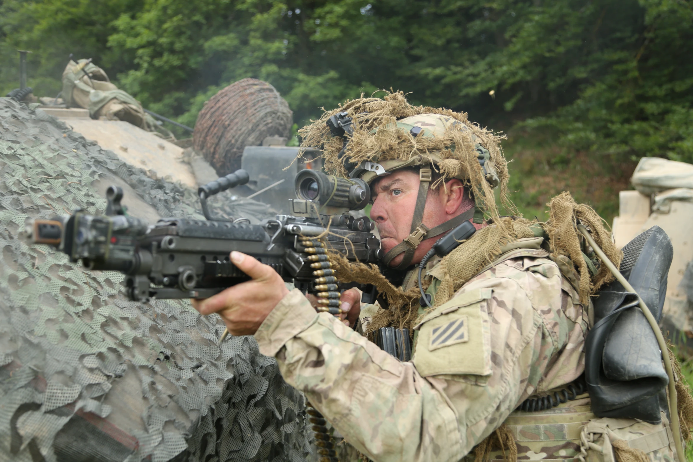 a soldier is shooting at a machine gun